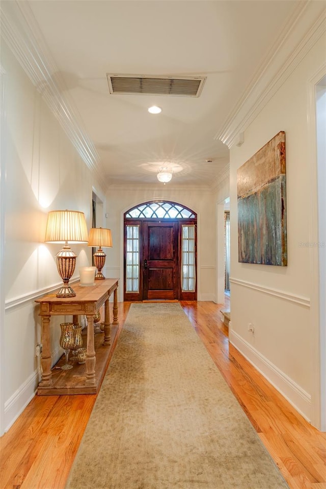 entrance foyer with wood-type flooring and ornamental molding