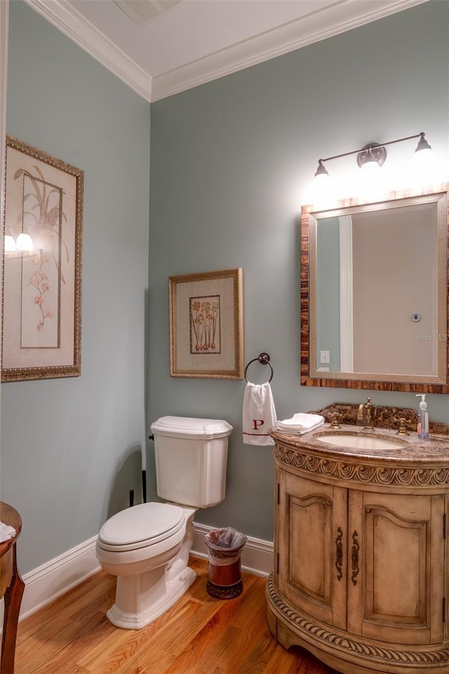 bathroom with hardwood / wood-style floors, vanity, toilet, and crown molding