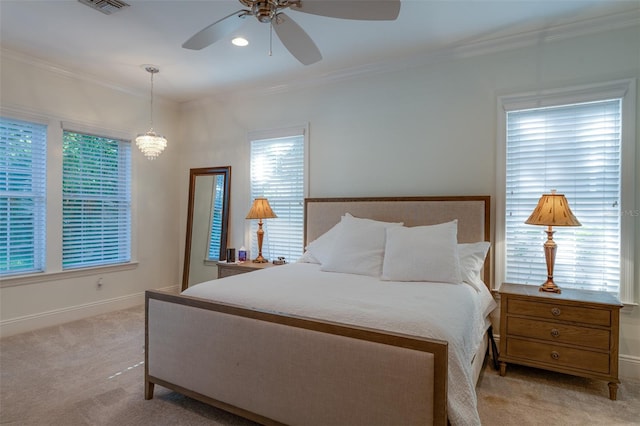 carpeted bedroom with multiple windows, ceiling fan with notable chandelier, and ornamental molding