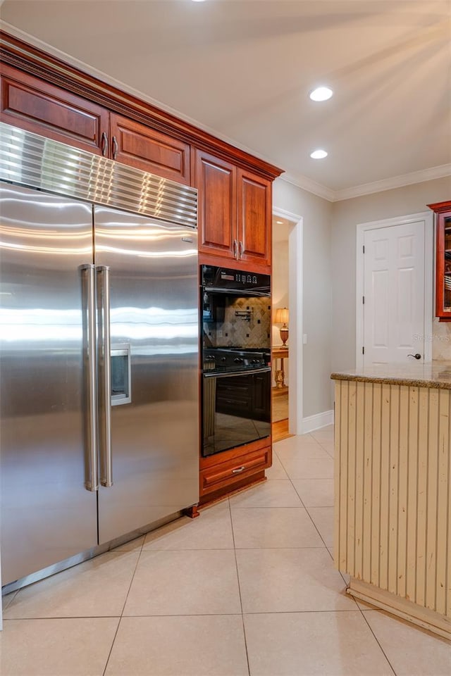 kitchen featuring light tile patterned floors, black double oven, crown molding, and built in fridge