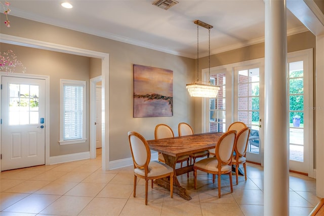 dining space featuring a healthy amount of sunlight, light tile patterned flooring, ornate columns, and ornamental molding