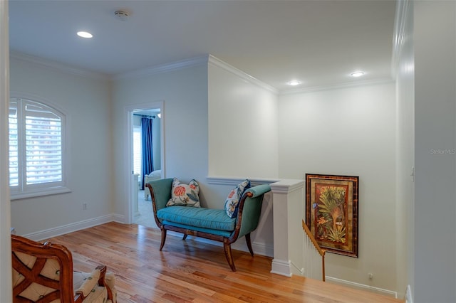 living area with light hardwood / wood-style flooring and ornamental molding