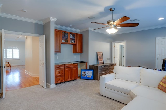 living room with ceiling fan, light colored carpet, and crown molding