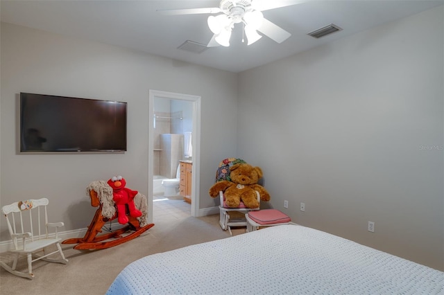 carpeted bedroom with ensuite bathroom and ceiling fan