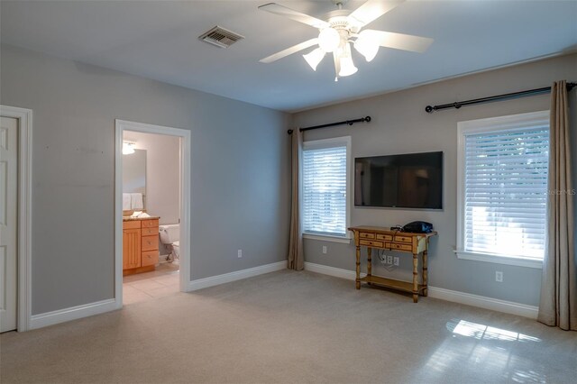 carpeted living room with ceiling fan and plenty of natural light