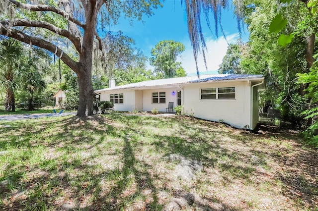 rear view of property featuring a yard