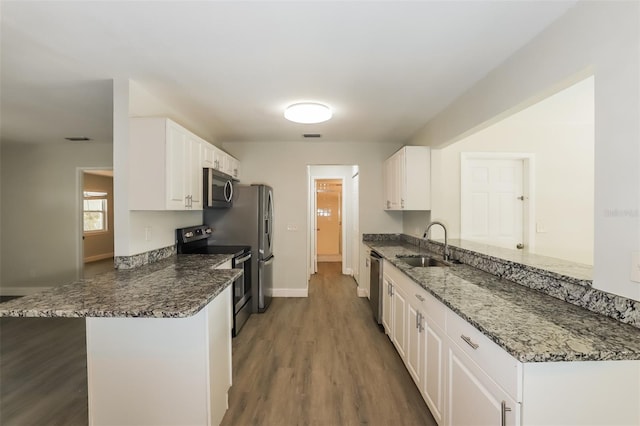 kitchen featuring kitchen peninsula, white cabinetry, sink, and appliances with stainless steel finishes