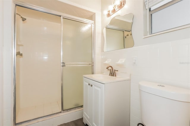 bathroom featuring toilet, vanity, tile walls, and walk in shower