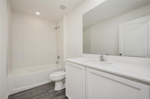 full bathroom with vanity, toilet, hardwood / wood-style flooring, and tiled shower / bath combo