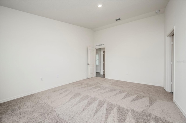 carpeted empty room featuring a towering ceiling