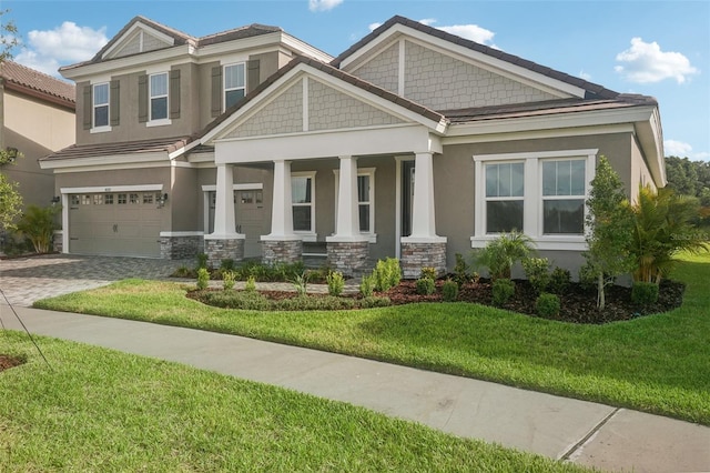 craftsman-style house with a porch, a garage, and a front lawn