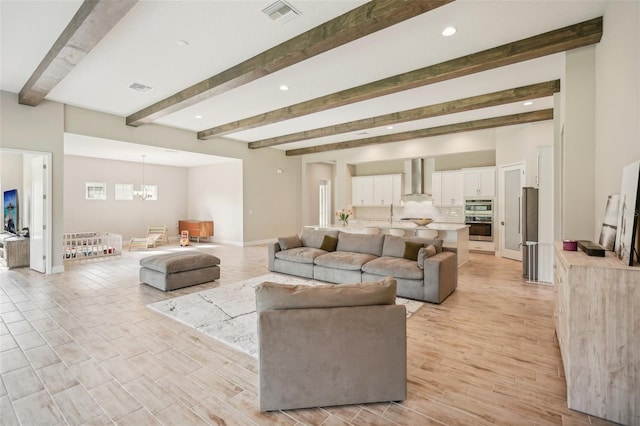 living room with beam ceiling and an inviting chandelier