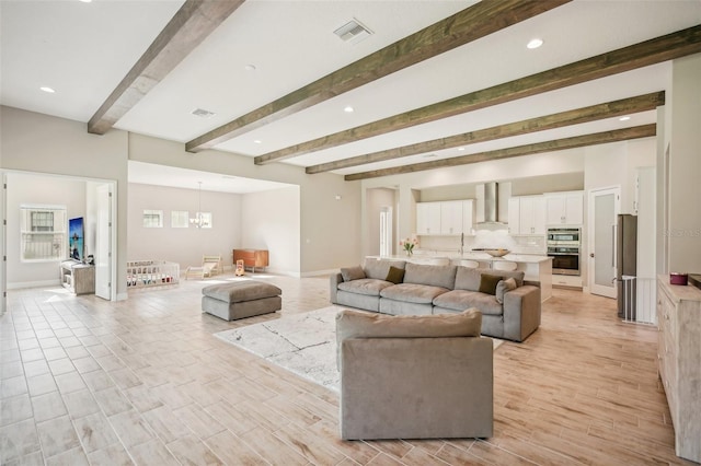 living room featuring beam ceiling and an inviting chandelier