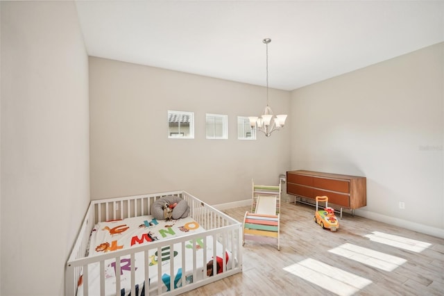 bedroom featuring a notable chandelier and light hardwood / wood-style flooring