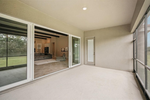 unfurnished sunroom with beam ceiling