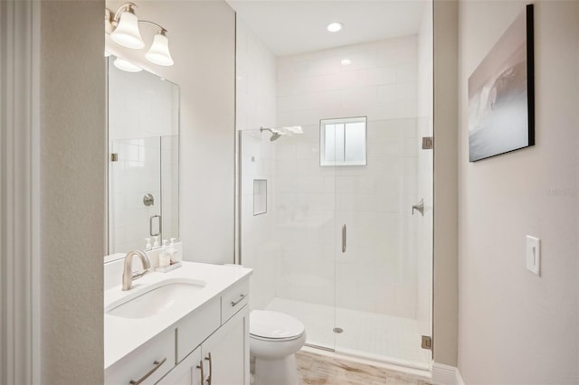 bathroom with vanity, toilet, and an enclosed shower