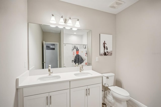 bathroom with a shower with door, vanity, and toilet