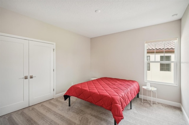 carpeted bedroom with multiple windows and a textured ceiling