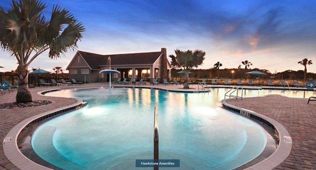 pool at dusk featuring a patio area