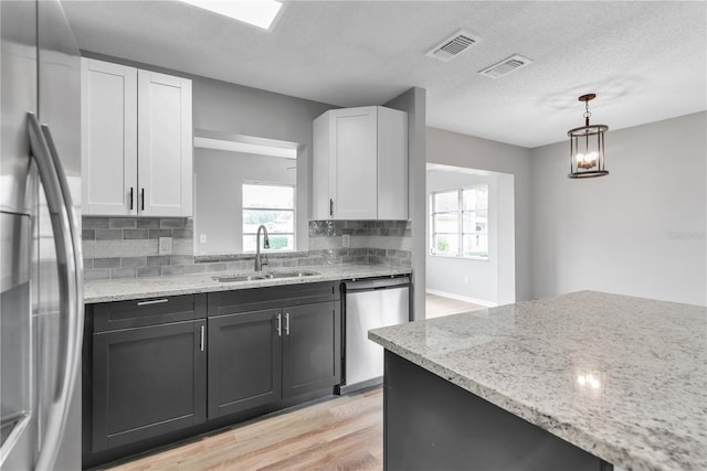 kitchen featuring white cabinetry, visible vents, appliances with stainless steel finishes, and a sink