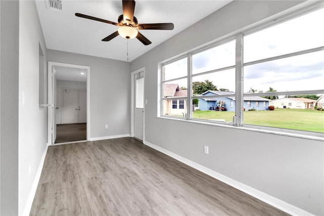 unfurnished bedroom featuring a closet, visible vents, a spacious closet, wood finished floors, and baseboards