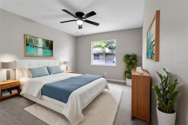 bedroom featuring a ceiling fan, carpet, a textured ceiling, and baseboards