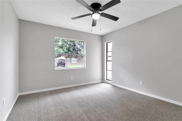 carpeted empty room featuring a ceiling fan, baseboards, and a textured ceiling