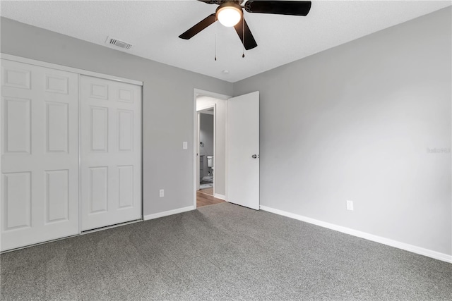 unfurnished bedroom featuring a ceiling fan, visible vents, baseboards, a closet, and carpet