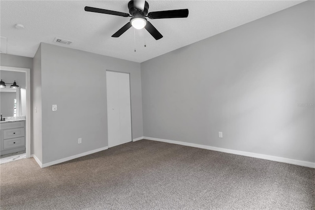 unfurnished bedroom featuring carpet floors, baseboards, visible vents, and a textured ceiling