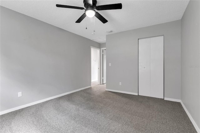 unfurnished bedroom with a textured ceiling, a closet, carpet, and baseboards