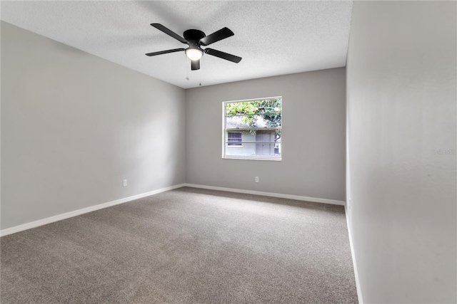 spare room with carpet floors, a textured ceiling, and baseboards