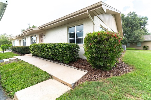 exterior space with a front lawn and stucco siding