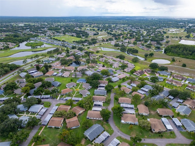 bird's eye view with golf course view, a water view, and a residential view