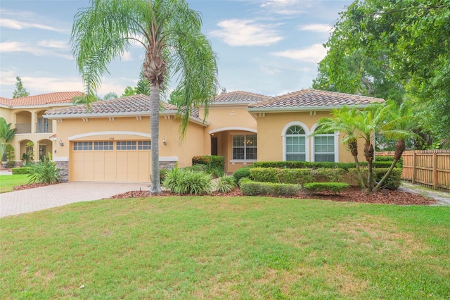 mediterranean / spanish home with a front yard and a garage