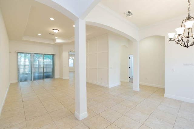 unfurnished room featuring a chandelier, a tray ceiling, crown molding, and light tile patterned flooring