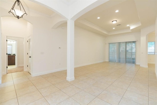 empty room featuring light tile patterned flooring and a tray ceiling