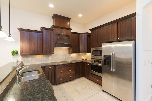 kitchen featuring dark stone counters, custom exhaust hood, stainless steel appliances, sink, and pendant lighting