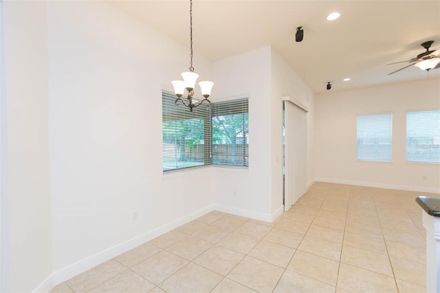 unfurnished room with light tile patterned flooring and ceiling fan with notable chandelier