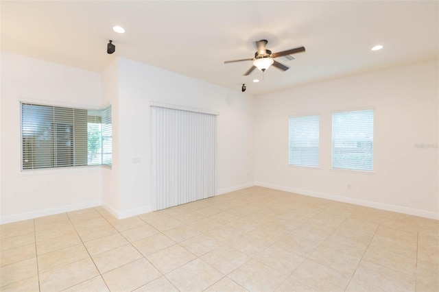 tiled empty room featuring ceiling fan