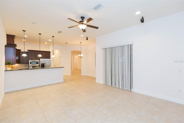 kitchen with decorative backsplash, appliances with stainless steel finishes, dark brown cabinets, ceiling fan, and decorative light fixtures