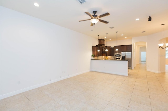 kitchen featuring ceiling fan with notable chandelier, kitchen peninsula, light tile patterned floors, appliances with stainless steel finishes, and dark brown cabinetry