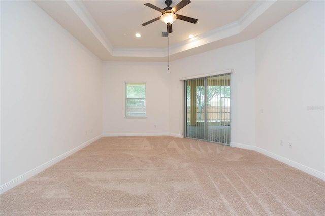 spare room with ceiling fan, crown molding, light carpet, and a tray ceiling