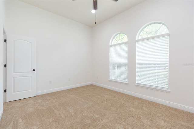 carpeted empty room with ceiling fan and lofted ceiling