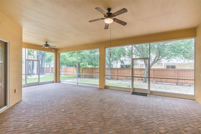 unfurnished sunroom featuring ceiling fan