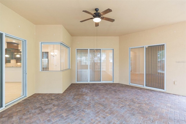 interior space with ceiling fan with notable chandelier