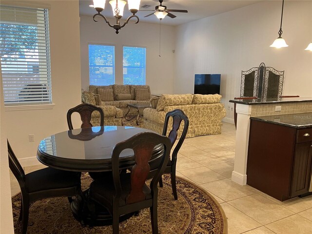 dining room featuring light tile patterned floors and ceiling fan with notable chandelier