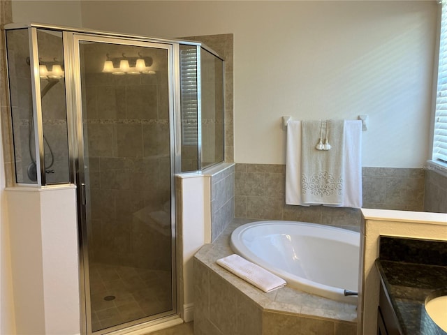 bathroom featuring vanity and independent shower and bath