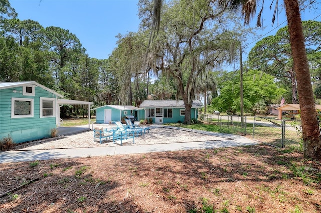 rear view of house featuring a carport and an outdoor structure