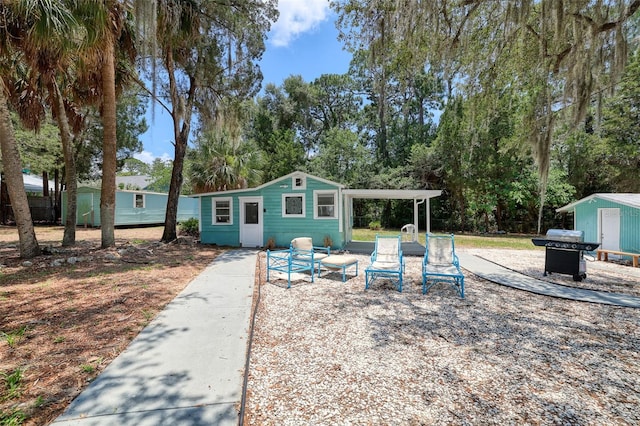 rear view of house with a storage unit