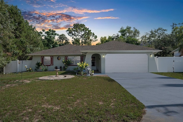 single story home with a garage and a lawn